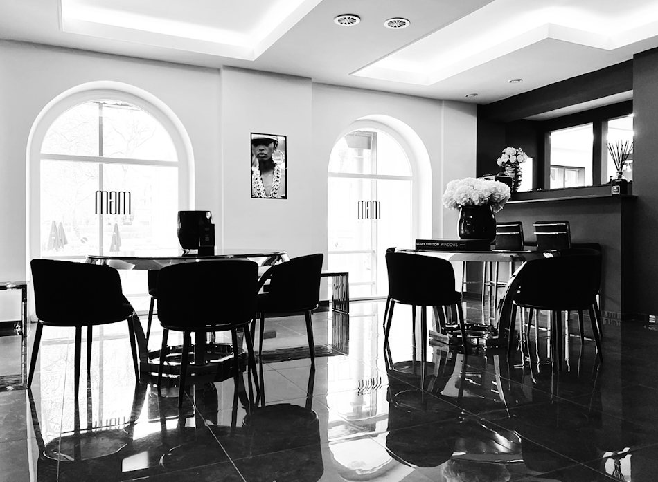 Lounge der Agentur mit Rundbogenfenstern und schwarzen Sesseln